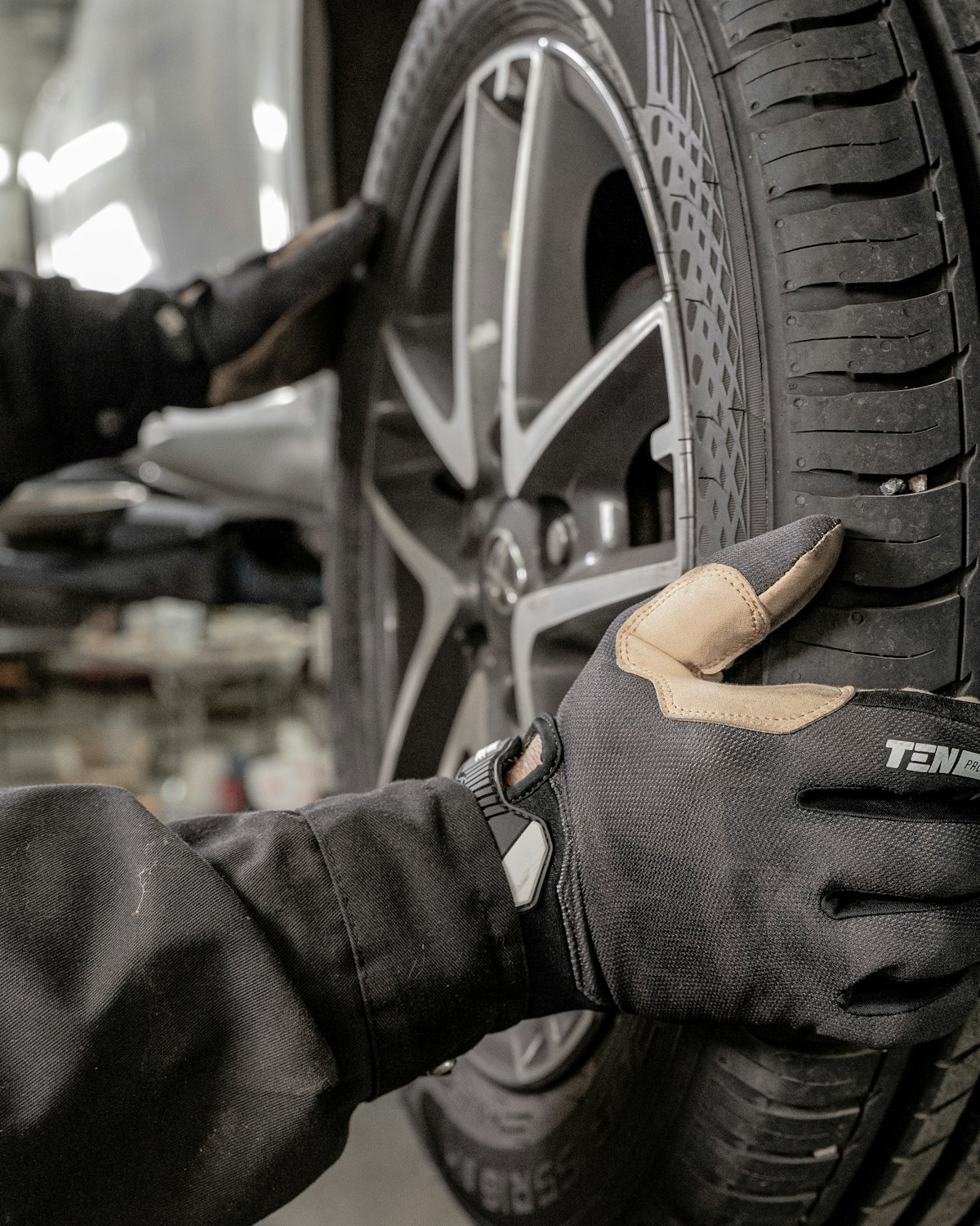 Mechaniker mit Handschuhen montiert ein Rad